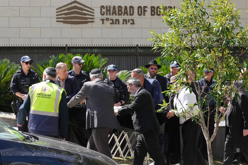 A coffin is wheeled into a synagogue in Bondi before the funeral of Rabbi Eli Schlanger.