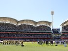 Australian and English players listen to a performance sung by John Williamson.