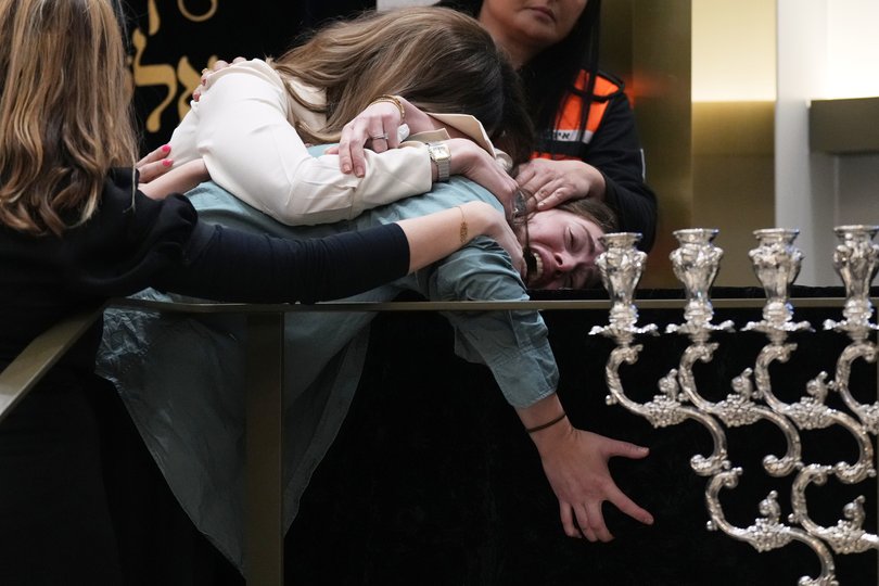 Family react at the coffin of Rabbi Eli Schlanger during his funeral on Wednesday.
