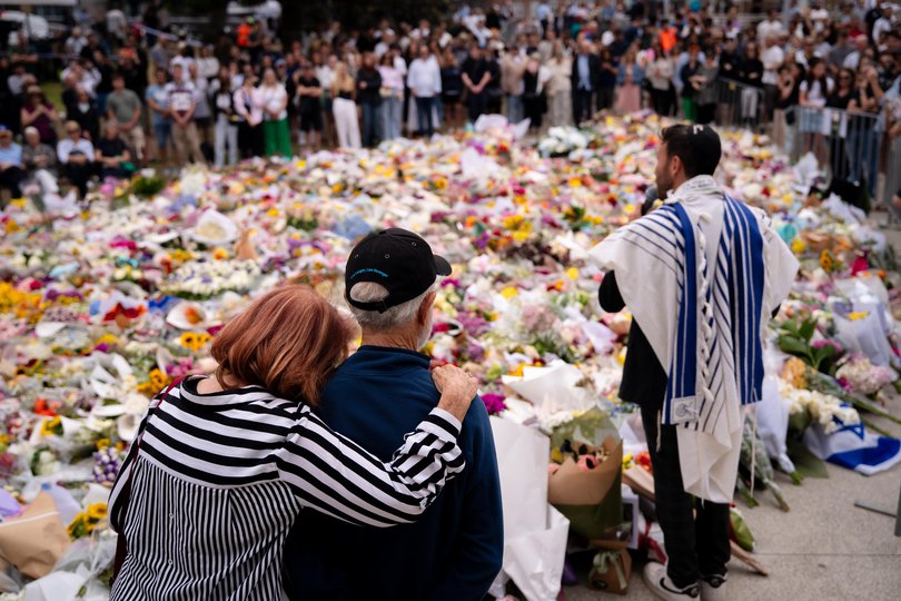 People visit a memorial at Bondi Pavilion before a candlelight vigil at Bondi Beach.