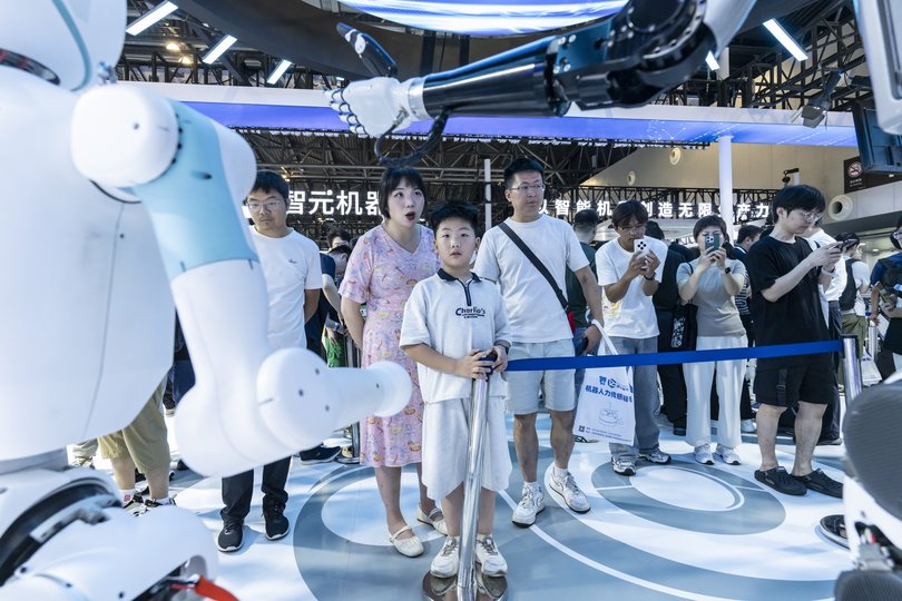 Attendees watch humanoid robots on display at the World Artificial Intelligence Conference in Shanghai, China, July 28, 2025.