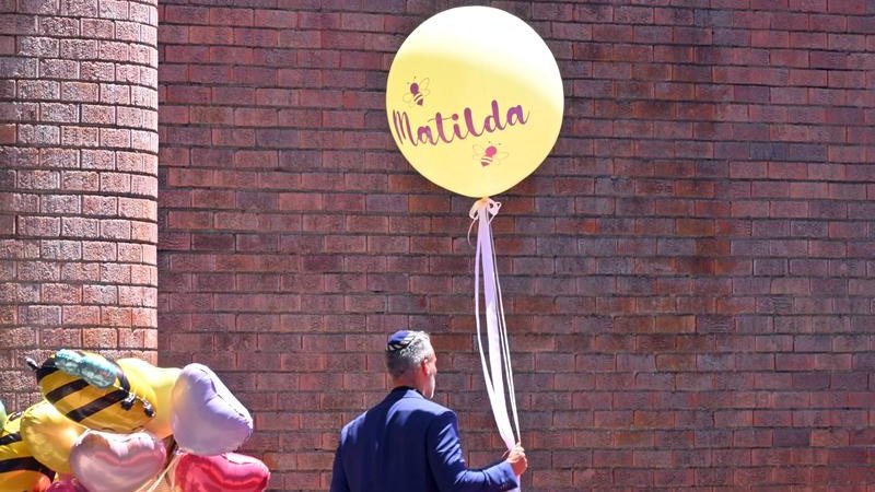 Community leader Alex Ryvchin carries a balloon at the funeral for 10-year-old Matilda. (Mick Tsikas/AAP PHOTOS)
