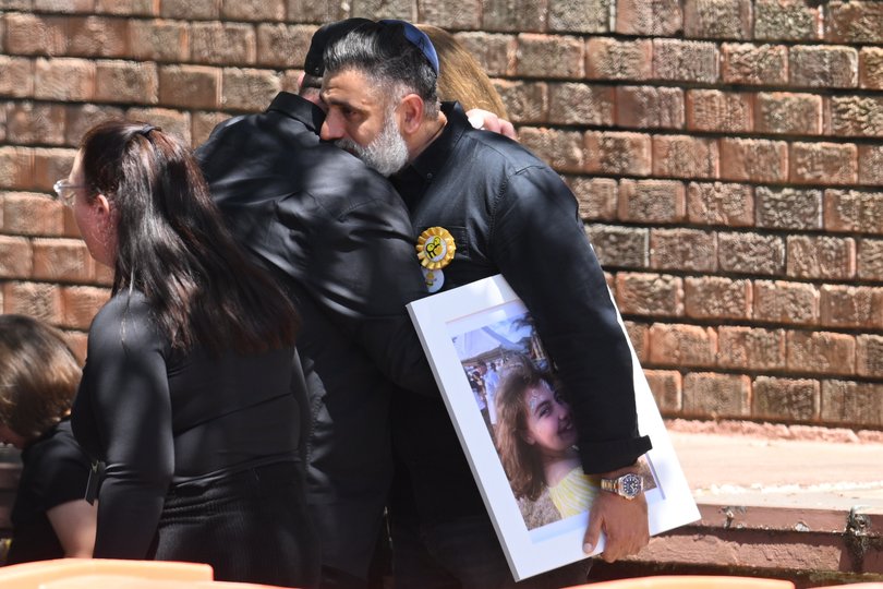 A man carries a photo of Bondi Beach mass shooting victim 10-year-old Matilda.