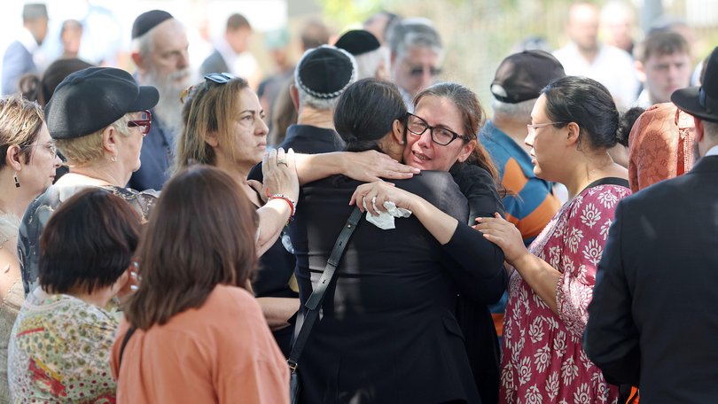Hannah Abesidon is comforted at her father Tibor’s funeral.