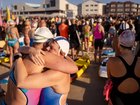 Mish, right, embraces her friend, Ingrid, as hundreds participate in a paddle-out and swim during sunrise at Bondi Beach to honour the victims of the Bondi Beach mass shooting.