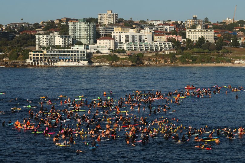 Members of the Bondi community pay their respects during a Paddle Out.