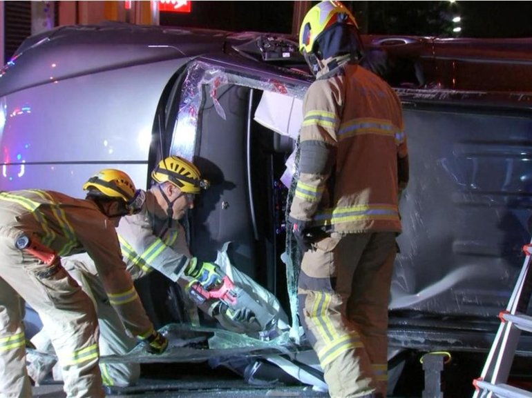Emergency crews removed the windscreen to pull two people to safety after a car hit a parked vehicle and flipped onto its side on Mount Alexander Rd, Ascot Vale, in Melbourne’s inner north. 7News