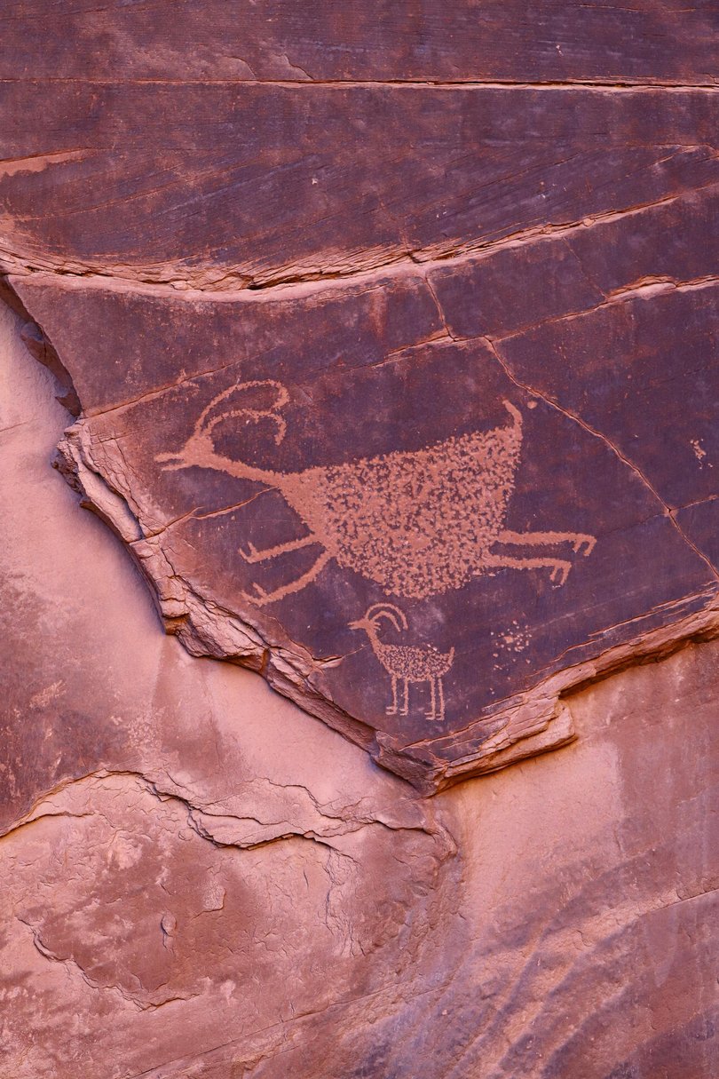 A tour vehicle drives along a road that loops through Monument Valley. 