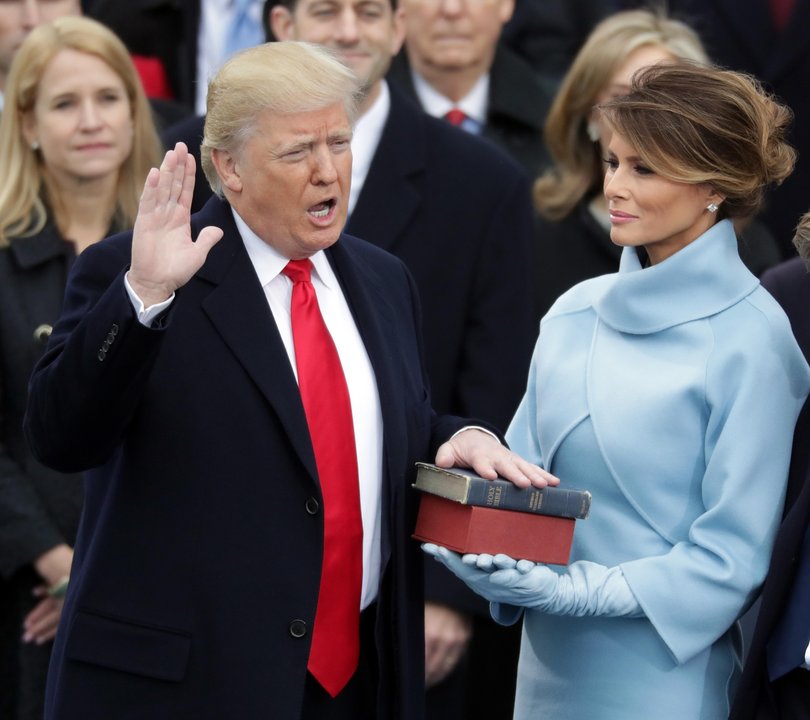 Donald Trump takes the oath of office as his wife Melania Trump holds the bible on the West Front of the US Capitol on January 20, 2017.