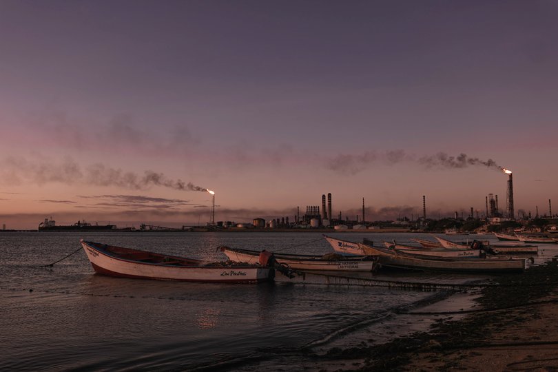 FILE — Oil tankers and the Cardon Refinery are visible on the horizon from a beach in Punto Fijo, El Salvador.