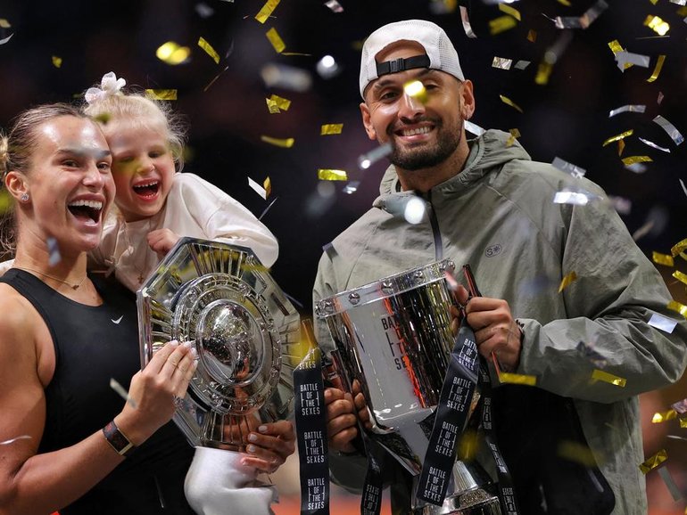 Aryna Sabalenka holds her goddaughter as she and Nick Kyrgios display their trophies in Dubai. (AP PHOTO)
