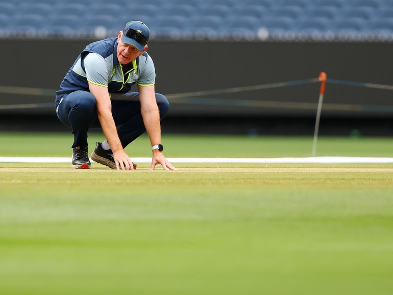 Andrew McDonald, Head Coach of Australia inspects the pitch.