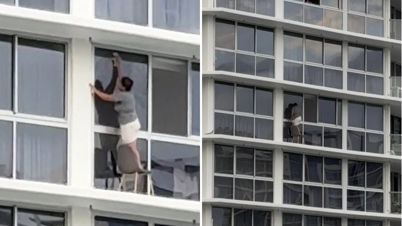 It seems one Gold Coast woman is prepared to risk her life for a clean apartment, as a shocking video of her standing on a chair next to an open ledge to clean her windows goes viral online.