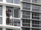 It seems one Gold Coast woman is prepared to risk her life for a clean apartment, as a shocking video of her standing on a chair next to an open ledge to clean her windows goes viral online.