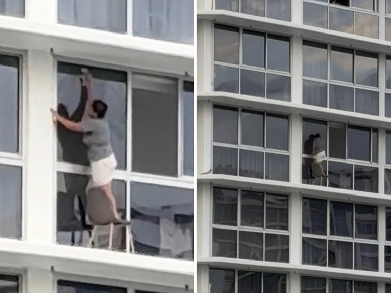 It seems one Gold Coast woman is prepared to risk her life for a clean apartment, as a shocking video of her standing on a chair next to an open ledge to clean her windows goes viral online.