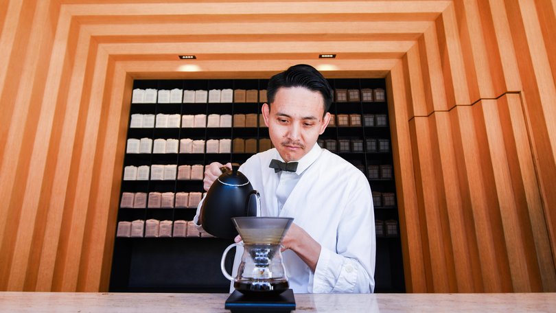 A barista works at Koffee Mameya Kakeru. 