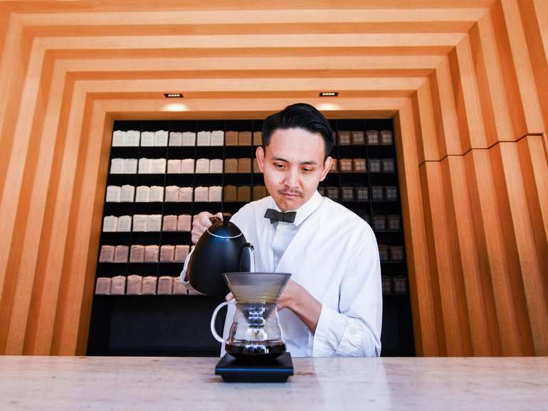 A barista works at Koffee Mameya Kakeru. 