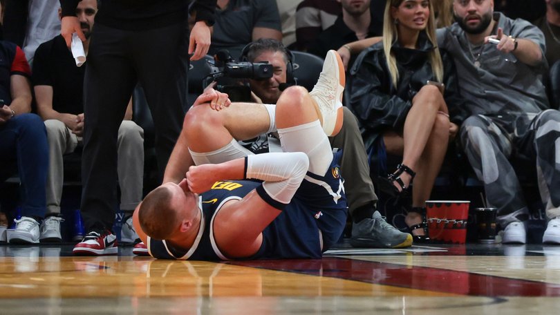  Denver Nuggets center Nikola Jokic holds his knee after an injury against the Miami Heat.