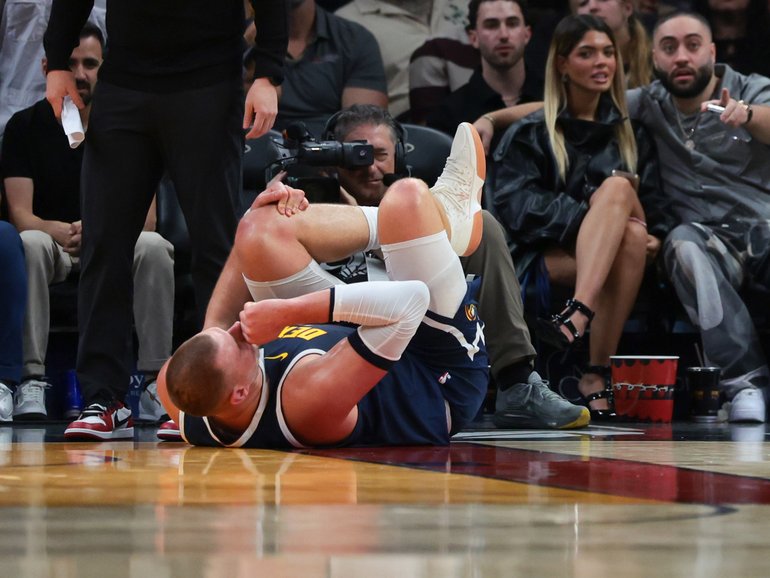  Denver Nuggets center Nikola Jokic holds his knee after an injury against the Miami Heat.