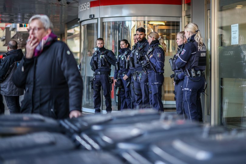  Police officers stand in front of the savings bank branch in the Buer district. After the break-in into the bank's vault, worried customers are demanding information.