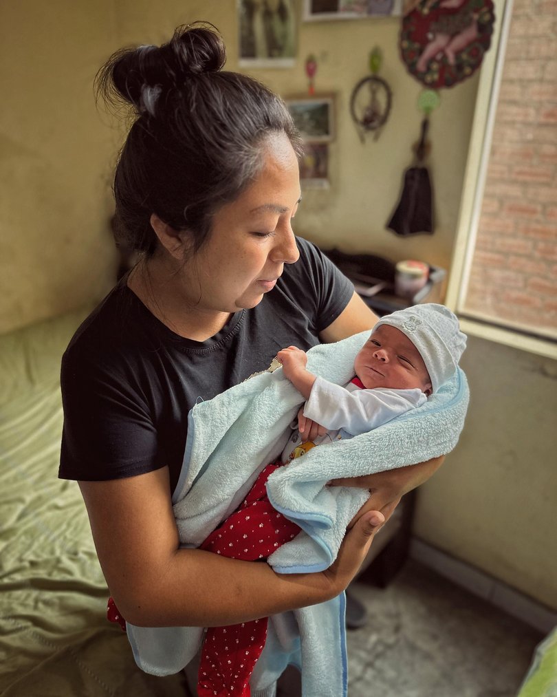 A baby born through the Fertilo process is held by his mother. MUST CREDIT: Gameto