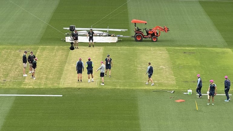 Australian officials inspect the SCG wicket ahead of a final call on selection.