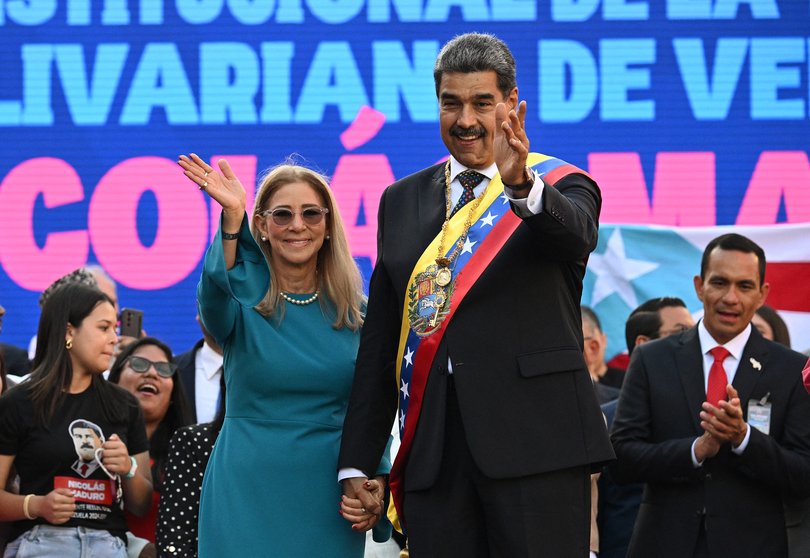 Venezuela's President Nicolas Maduro and his wife Cilia Flores wave to supporters in front of Miraflores presidential palace in Caracas on January 10, 2025.