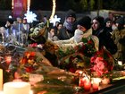 Mourners gather to leave flowers and candles at the scene after a fire broke out at Le Constellation bar on January 01, 2026 in Crans-Montana, Switzerland.