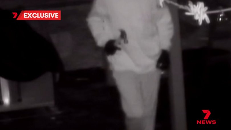 Another man can be seen inside the property carrying a hammer.