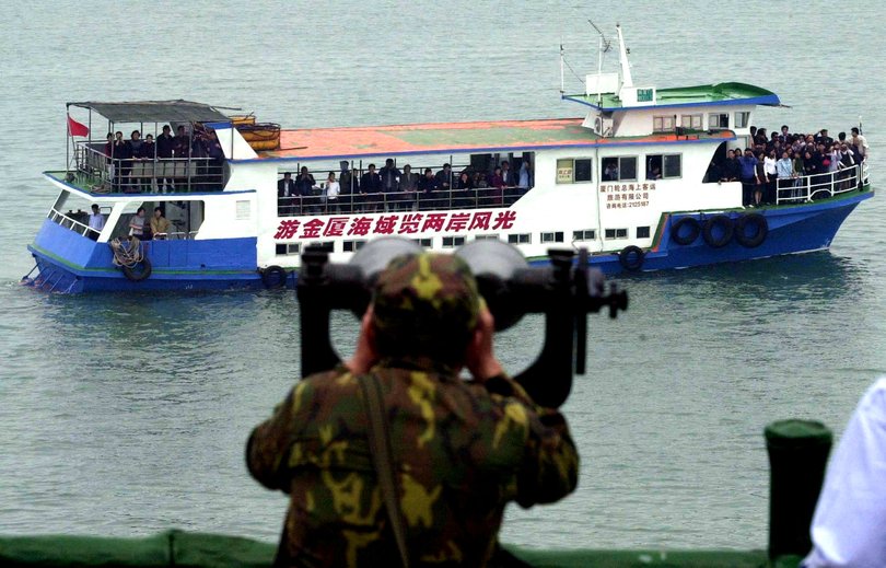 A Taiwanese soldier watches a mainland Chinese tour boat off the shore of the outermost Taiwan-held island.