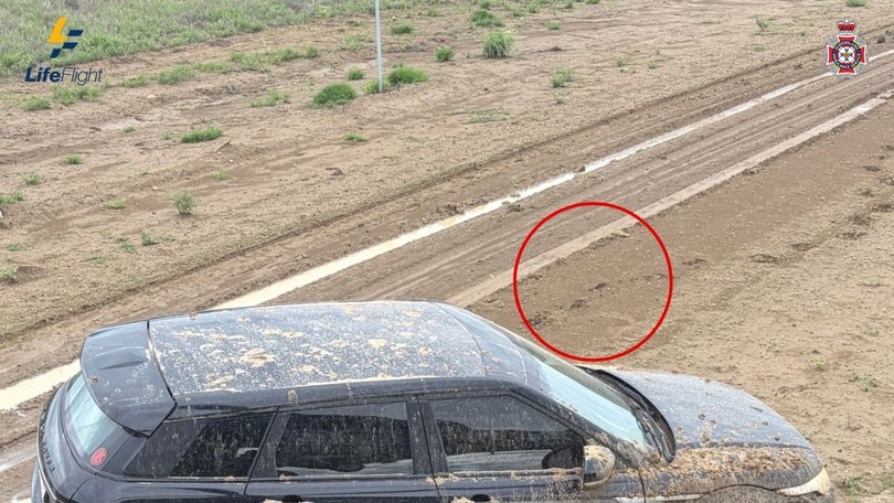 A close view shows the footprints leading from the bogged car, marking the start of the man’s 40-kilometre walk through floodwaters.