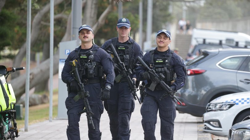 NSW Police carrying M4 assault rifles patrol Bondi Beach on New Year’s Eve.