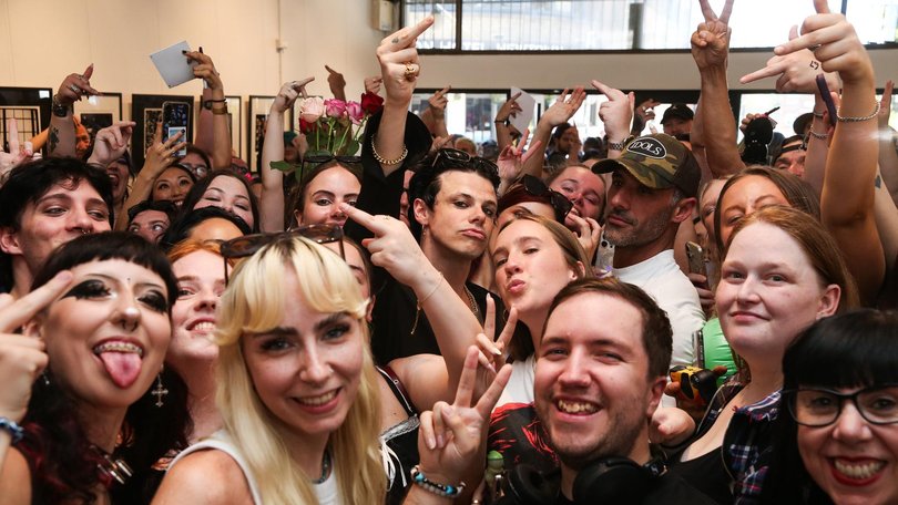 Hundreds of fans headed to the Newtown gallery for the chance to snag a photo with the international rocker (centre).
