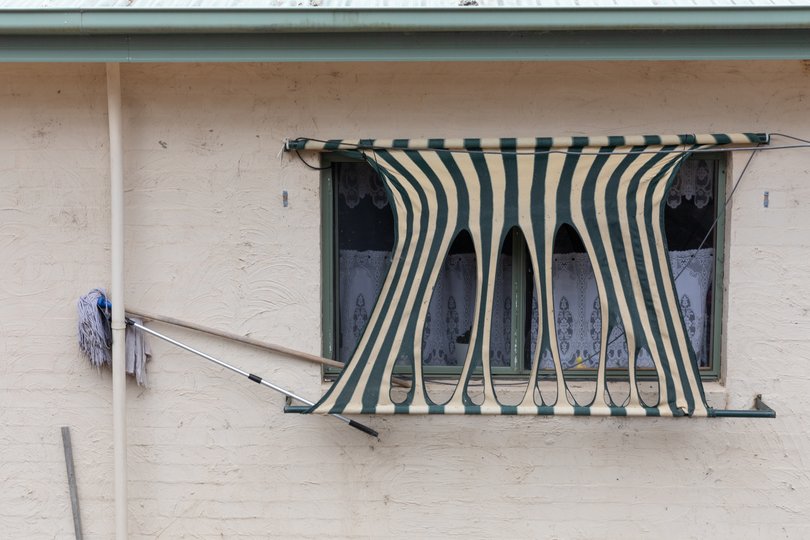 Melted window shades are seen at a burnt farm property.