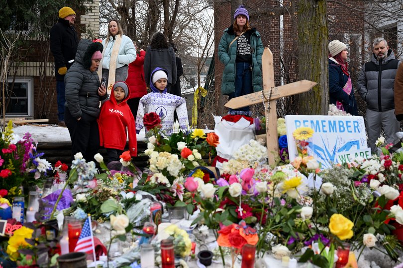 People gather at a makeshift memorial for Good on Thursday in Minneapolis.