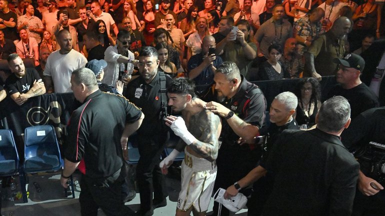 Michael Zerafa is escorted away after the chaotic finish. 