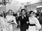 Valentino Garavani links arms with two models at the end of a fashion show at Lord & Taylor in New York, March 18, 1968. 