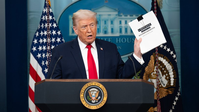 US President Donald Trump holds up a list of accomplishments.