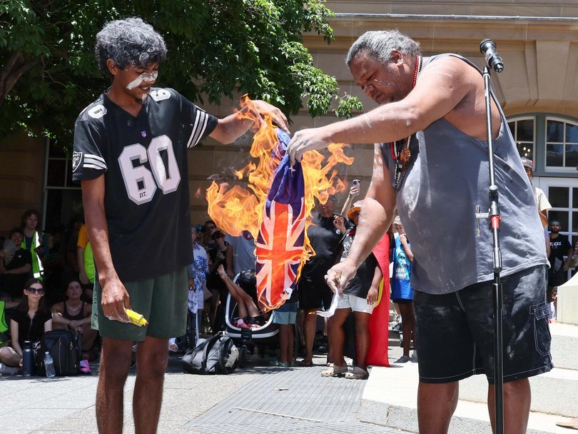 An Australian flag was burned as thousands of protestors gathered at Queens Gardens in Brisbane to protest against Australia Day. NewsWire/Tertius Pickard