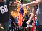 An Australian flag was burned as thousands of protesters gathered at Queens Gardens in Brisbane to protest against Australia Day. NewsWire/Tertius Pickard
