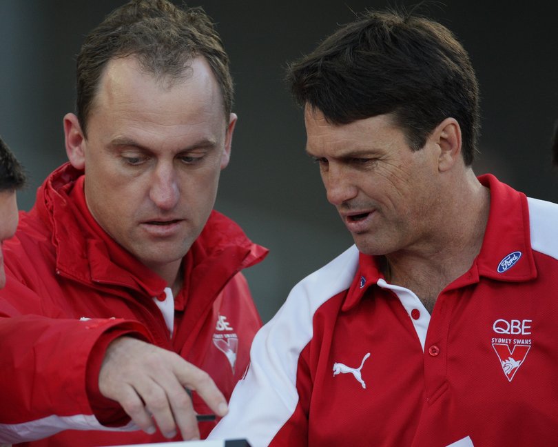 Sydney coach Paul Roos discusses tactics with assistant coach John Longmire at the three-quarter time break during the AFL Round 08 match between the Sydney Swans and the Essendon Bombers at ANZ Stadium.