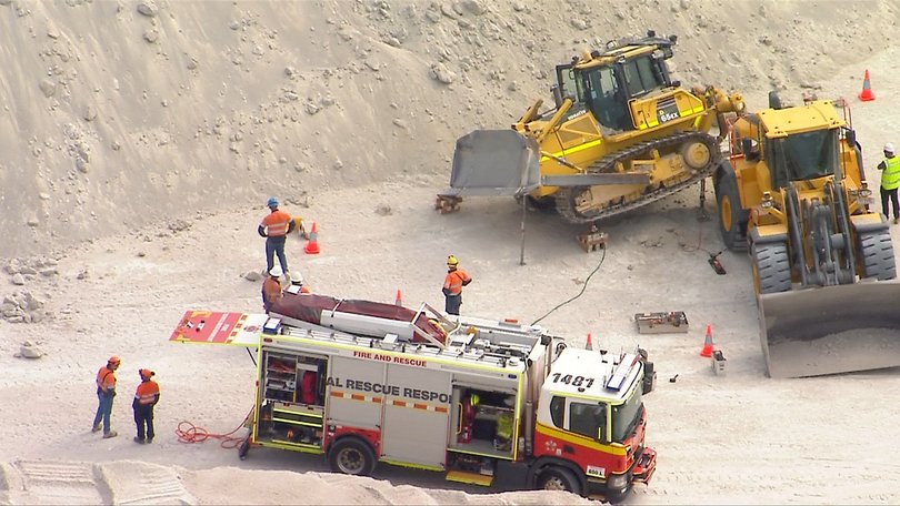 The bulldozer’s rear end was propped up by a jack.