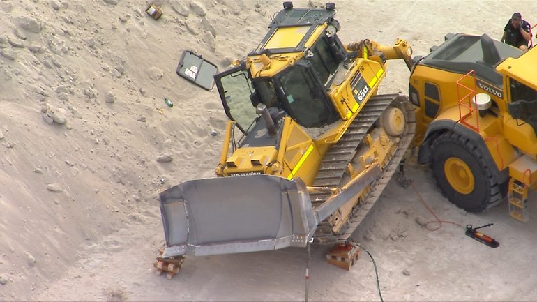 A worker has died after a bulldozer rolled over at a cement site.