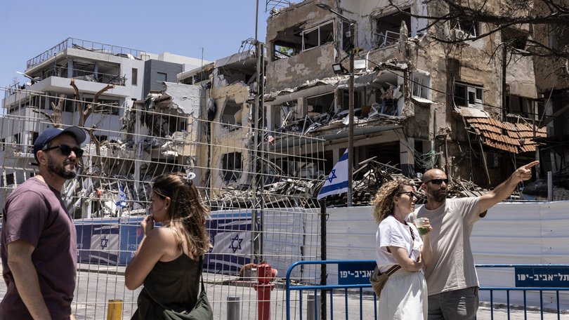 People assess the aftermath of an Iranian missile attack that destroyed residential buildings in Tel Aviv in June.
