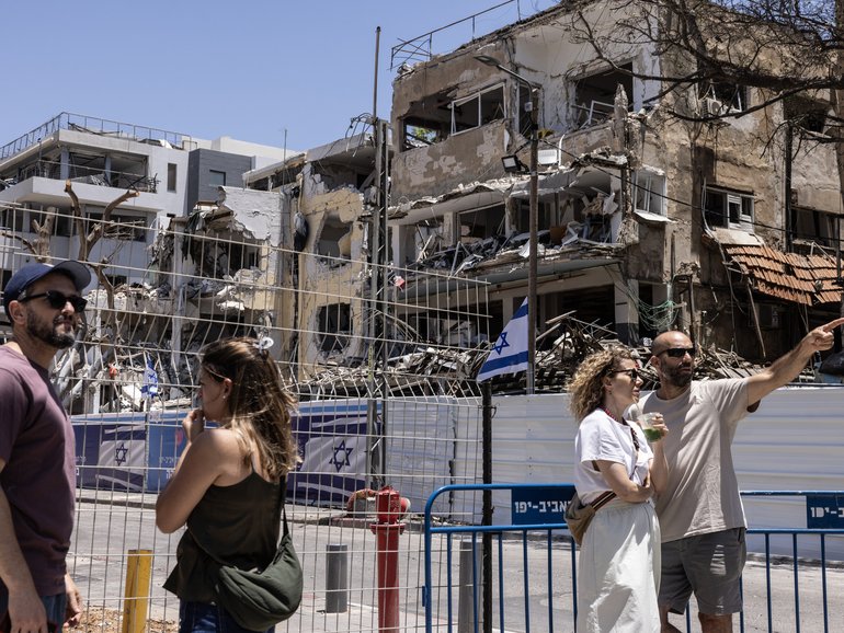 People assess the aftermath of an Iranian missile attack that destroyed residential buildings in Tel Aviv in June.