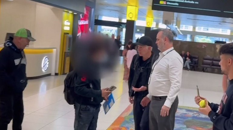 Tennis legend John McEnroe has lost his cool with a persistent fan at Melbourne Airport.