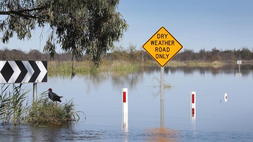 Around 450 people living in a remote outback town have been evacuated as floodwaters cut off roads. 