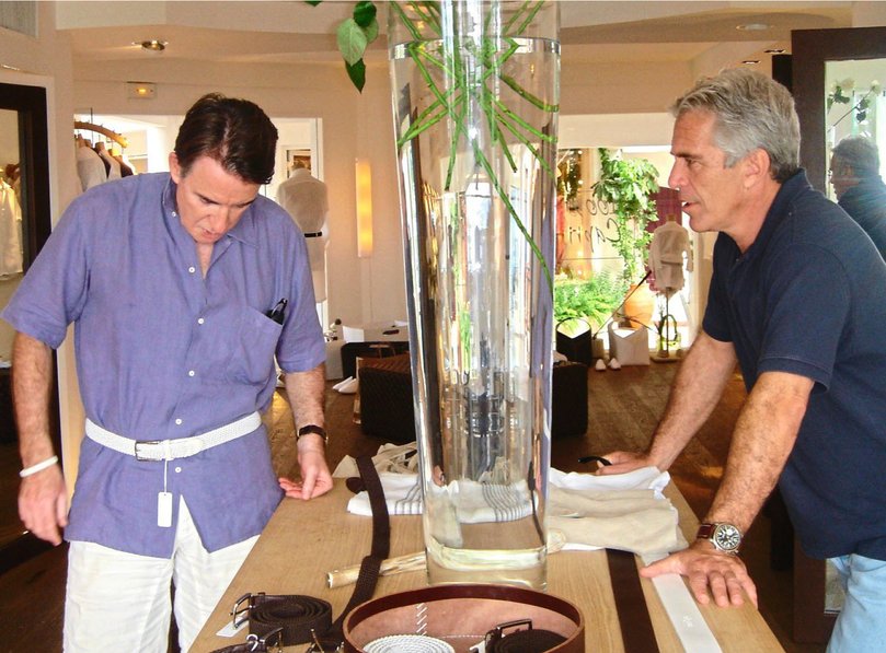 Lord Mandelson, then an EU commissioner, tries on a white belt in a store on St Barts as Epstein looks on.