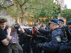 Demonstrators react to pepper spray during a protest against Israeli President Isaac Herzog's visit to Australia near Sydney's Town Hall.