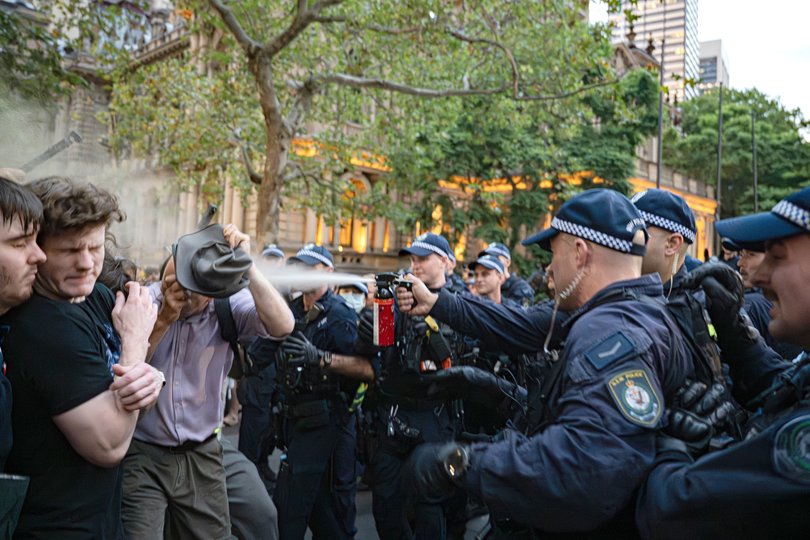 Demonstrators react to pepper spray during a protest against Israeli President Isaac Herzog's visit to Australia near Sydney's Town Hall.